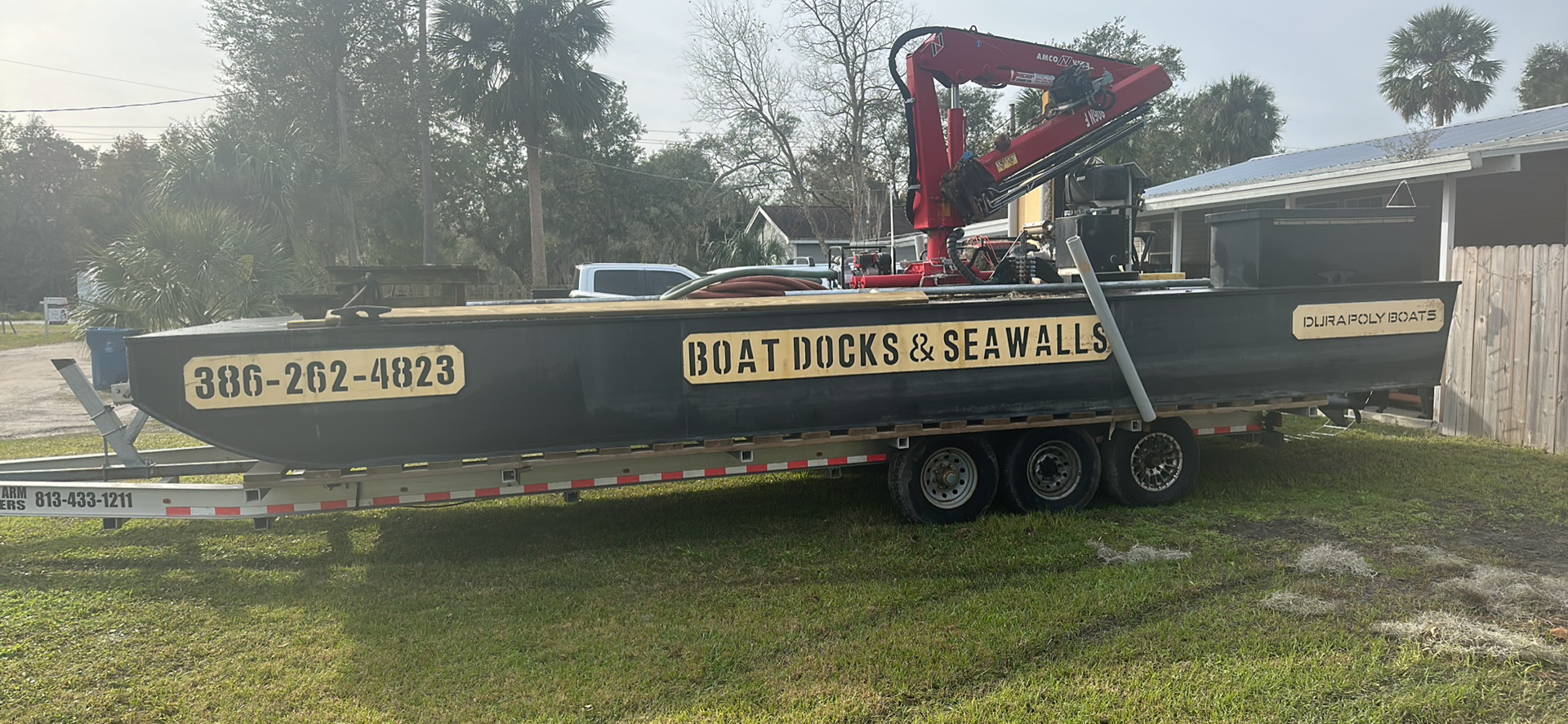 Ready to deliver Shoreline Marine Solutions barge with crane and gold highlights on a trailer.